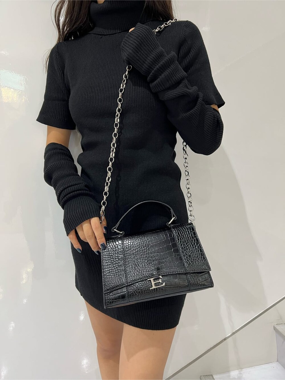 ブラック系のワンピース、ブラック系のブーツ、ブラック系のショルダーバッグを着用したレディースの秋コーディネートの4枚目の写真