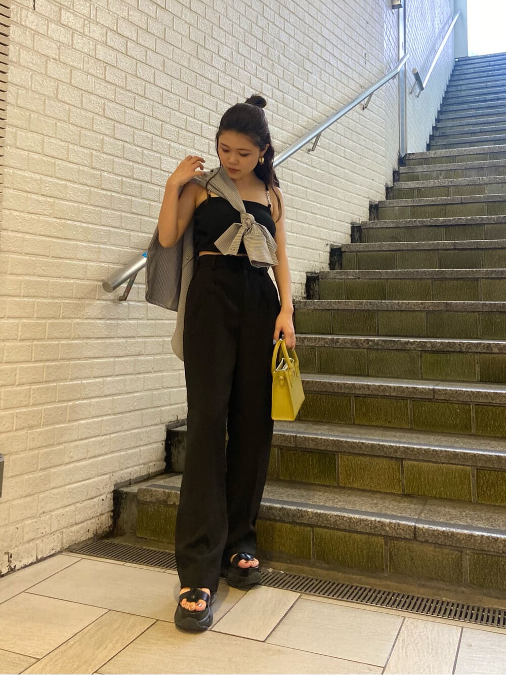 ブラック系のスラックス、ブラック系のサンダル、ブラック系のワンピースを着用したレディースの春コーディネートの5枚目の写真