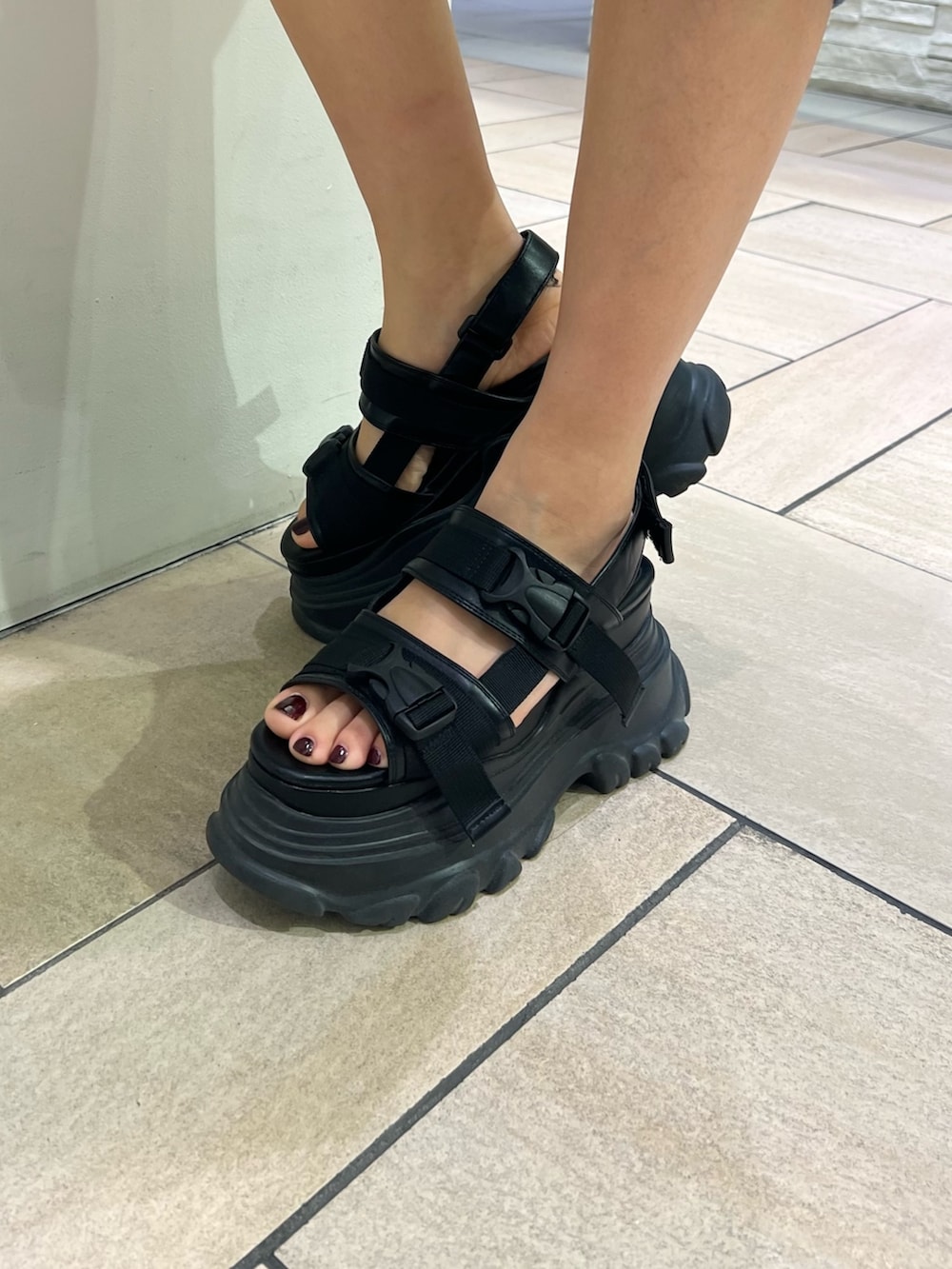 ブラック系のスカート、イエロー系のTシャツ/カットソー、ブラック系のサンダルを着用したレディースの春コーディネートの8枚目の写真