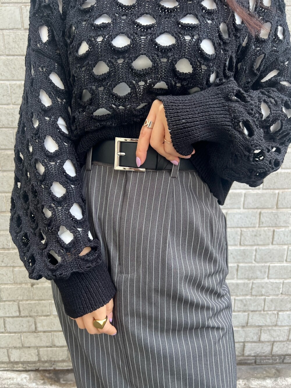 グレー系のスカート、ブラック系のニット/セーター、ブルー系のショルダーバッグを着用したレディースの冬コーディネートの6枚目の写真