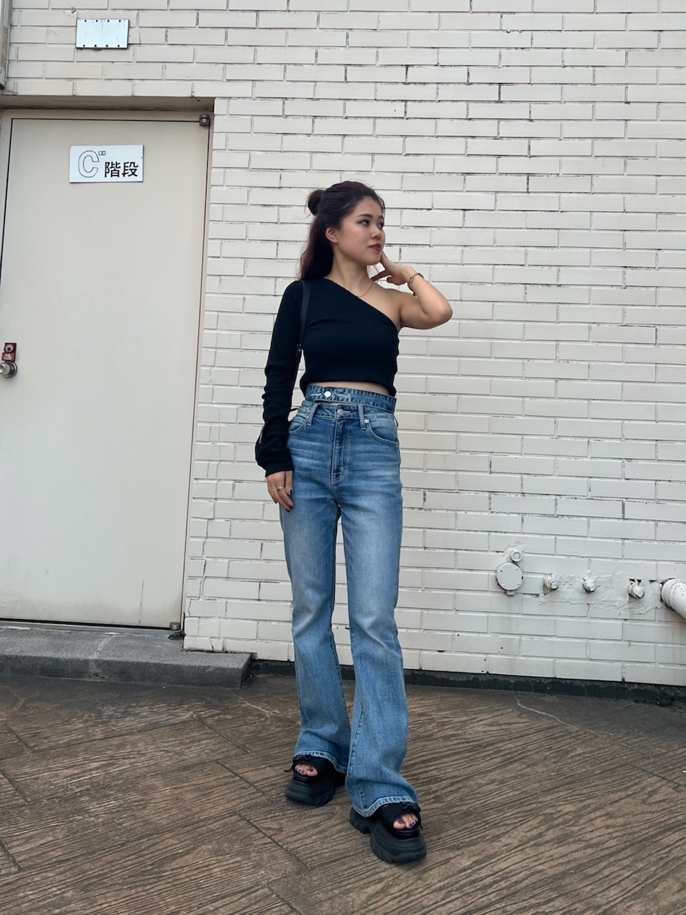 ブラック系のTシャツ/カットソー、ブラック系のサンダル、ブルー系のデニムパンツを着用したレディースの夏コーディネートの2枚目の写真