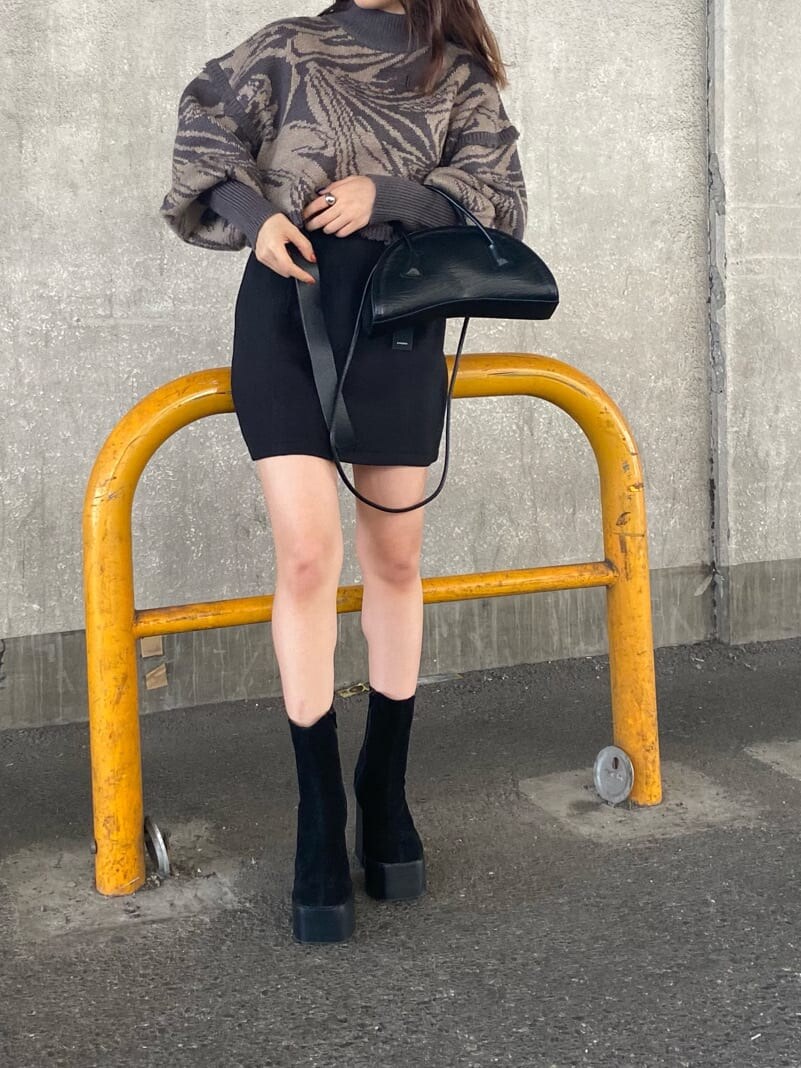 ブラック系のスカート、ブラック系のハンドバッグ、その他のニット/セーターを着用したレディースの秋コーディネートの2枚目の写真