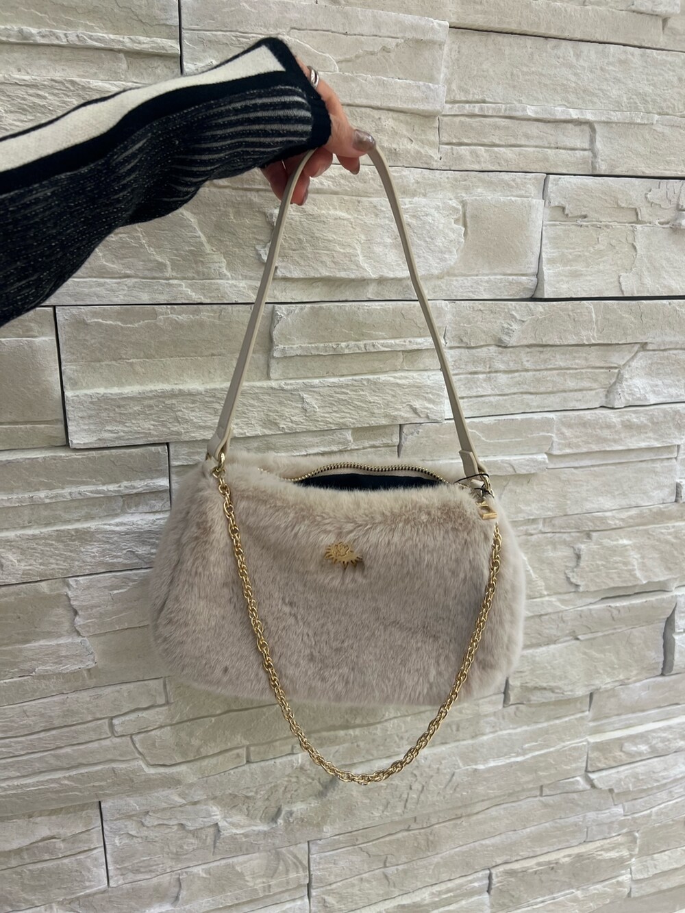 ブルー系のデニムパンツ、ホワイト系のショルダーバッグ、ブラック系のニット/セーターを着用したレディースの冬コーディネートの8枚目の写真