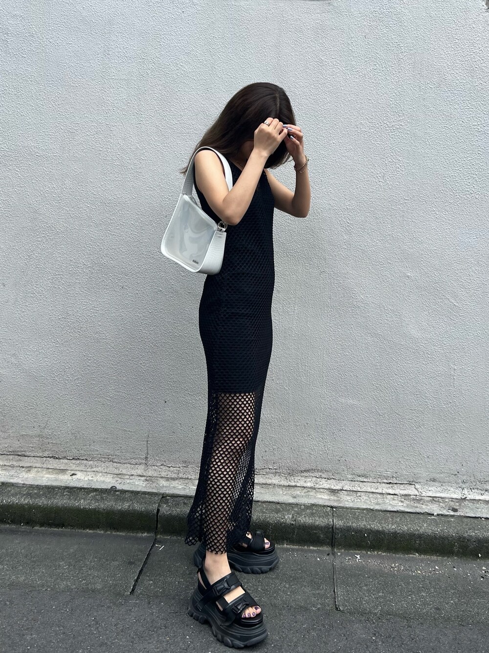 ブラック系のワンピース、ブラック系のサンダル、ホワイト系のハンドバッグを着用したレディースの夏コーディネートの3枚目の写真