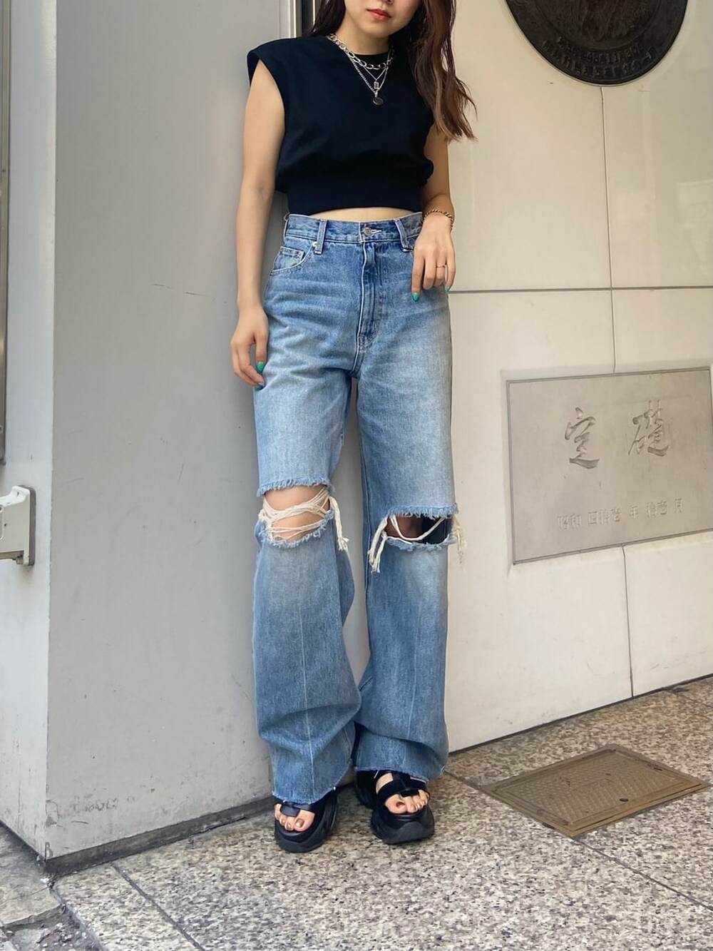 ブラック系のサンダル、ブラック系のTシャツ/カットソー、ブルー系のデニムパンツを着用したレディースの夏コーディネートの2枚目の写真