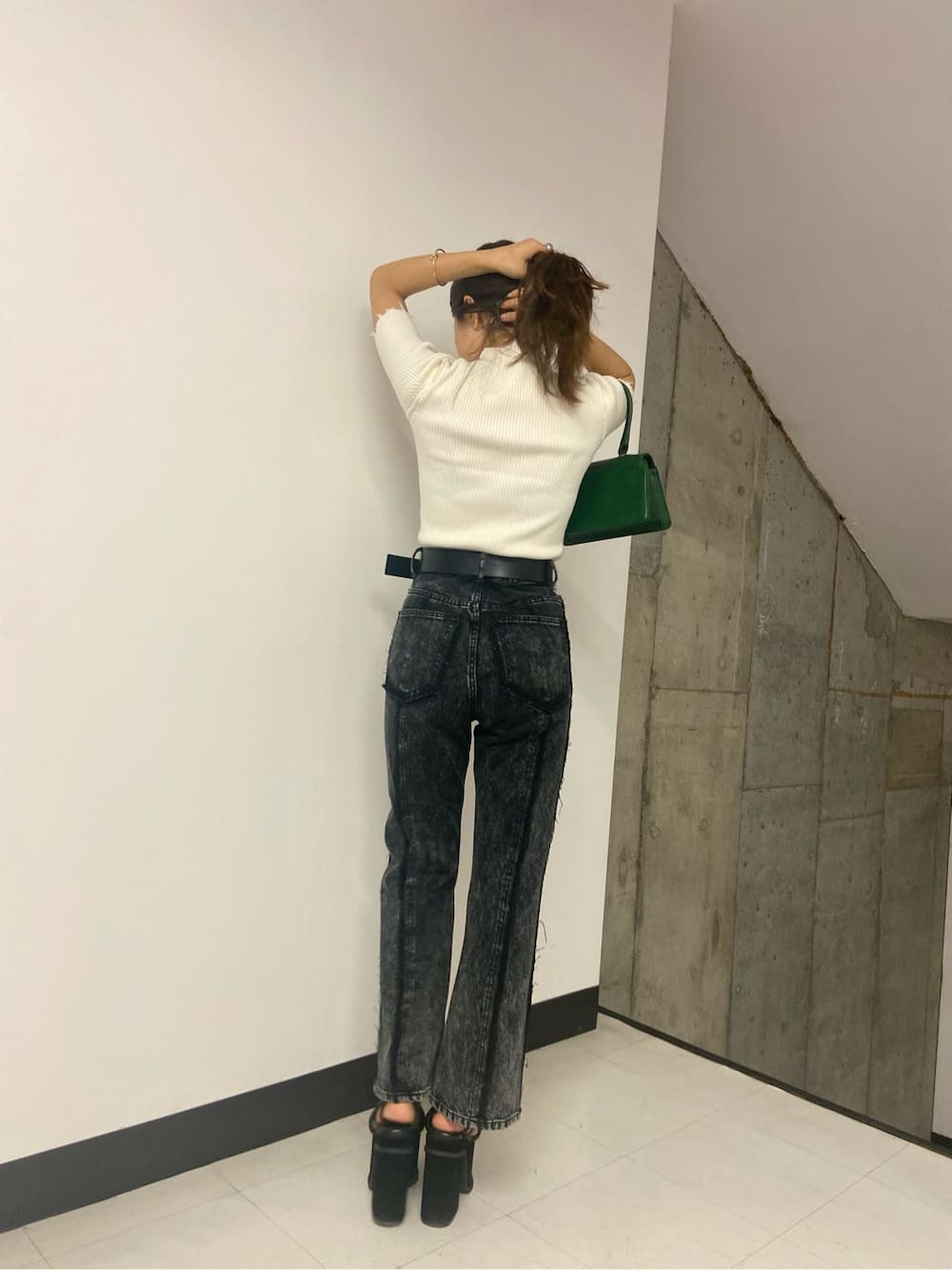 グリーン系のハンドバッグ、ブラック系のデニムパンツ、ホワイト系のニット/セーターを着用したレディースの夏コーディネートの3枚目の写真