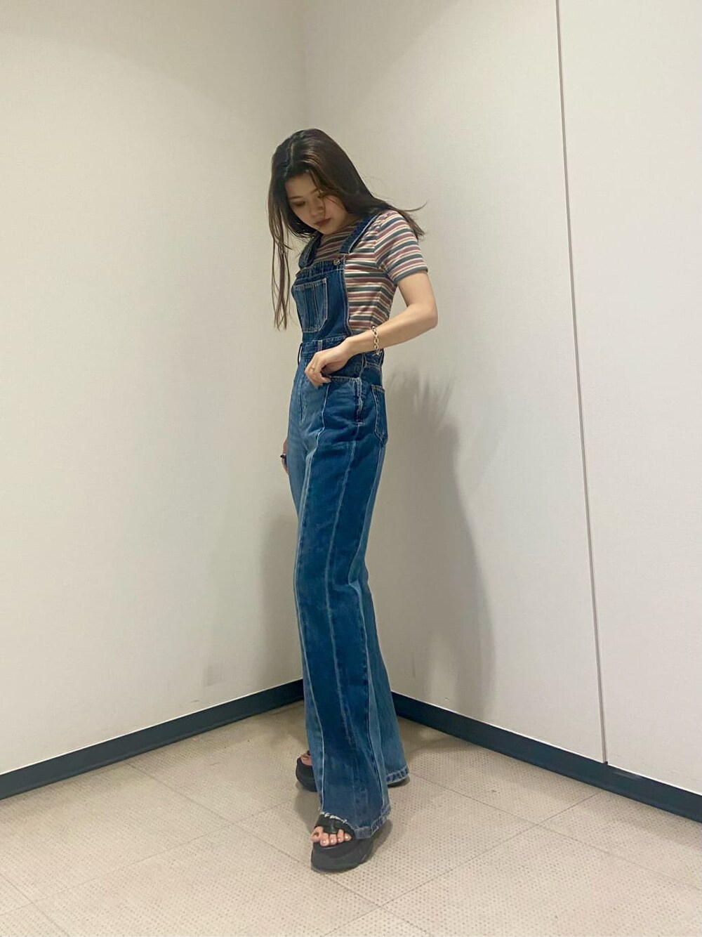 ブルー系のサロペット/オーバーオール、ブラック系のサンダル、グリーン系のTシャツ/カットソーを着用したレディースの夏コーディネートの7枚目の写真