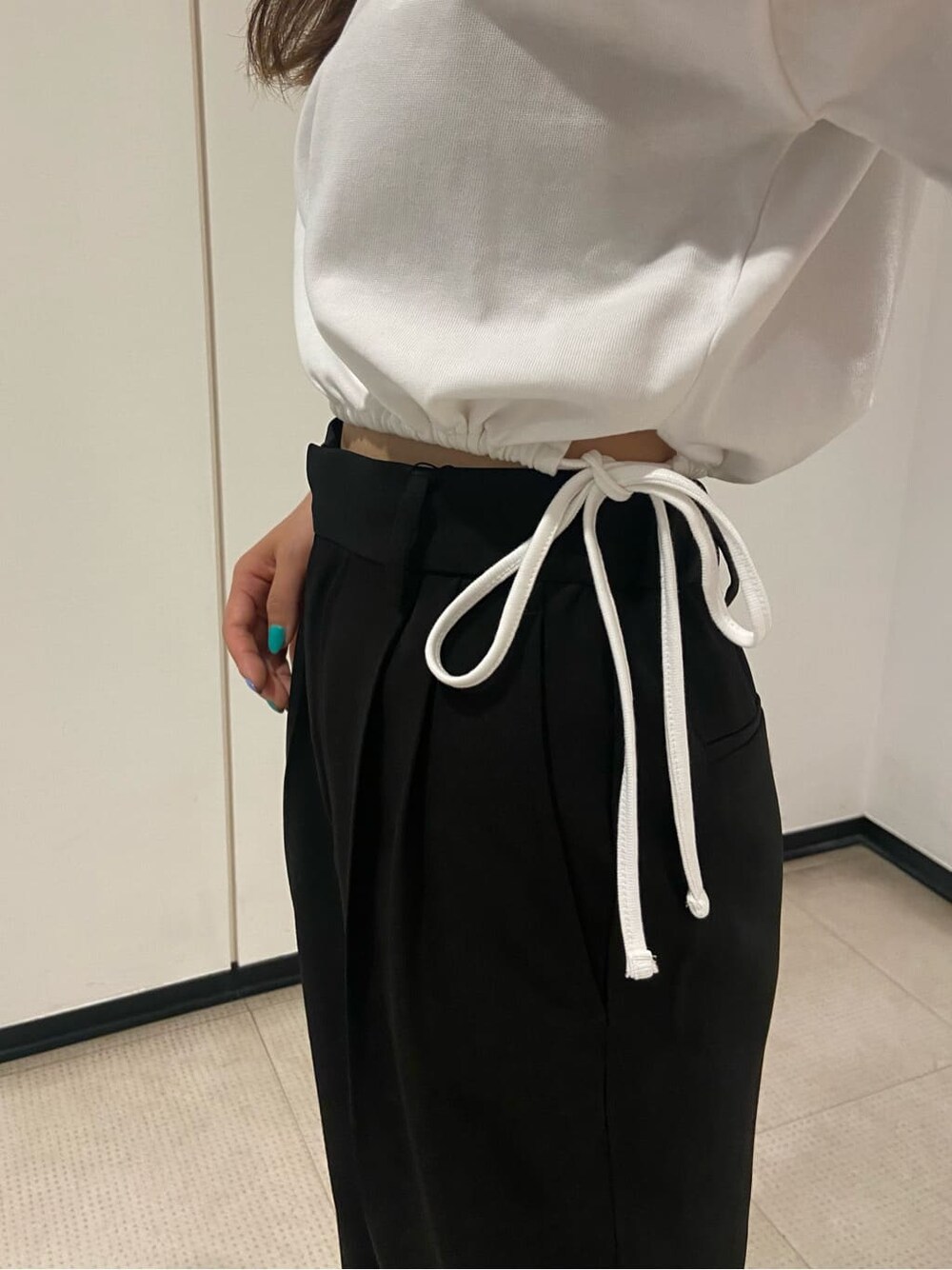 ブラック系のスラックス、ホワイト系のTシャツ/カットソー、イエロー系のショルダーバッグを着用したレディースの春コーディネートの6枚目の写真