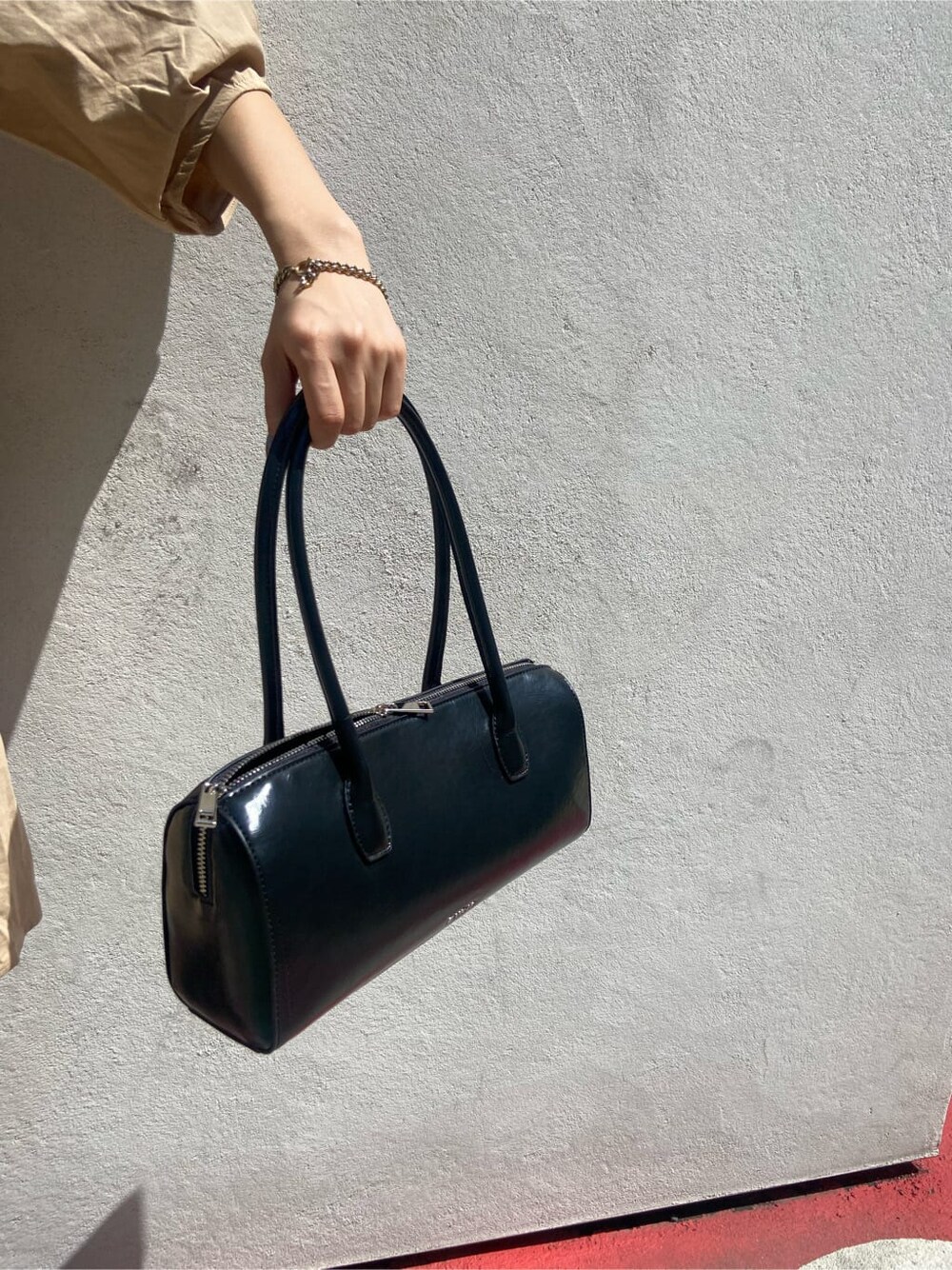 ブラック系のボストンバッグ、ブラック系のブーツ、ベージュ系のワンピースを着用したレディースの春コーディネートの8枚目の写真