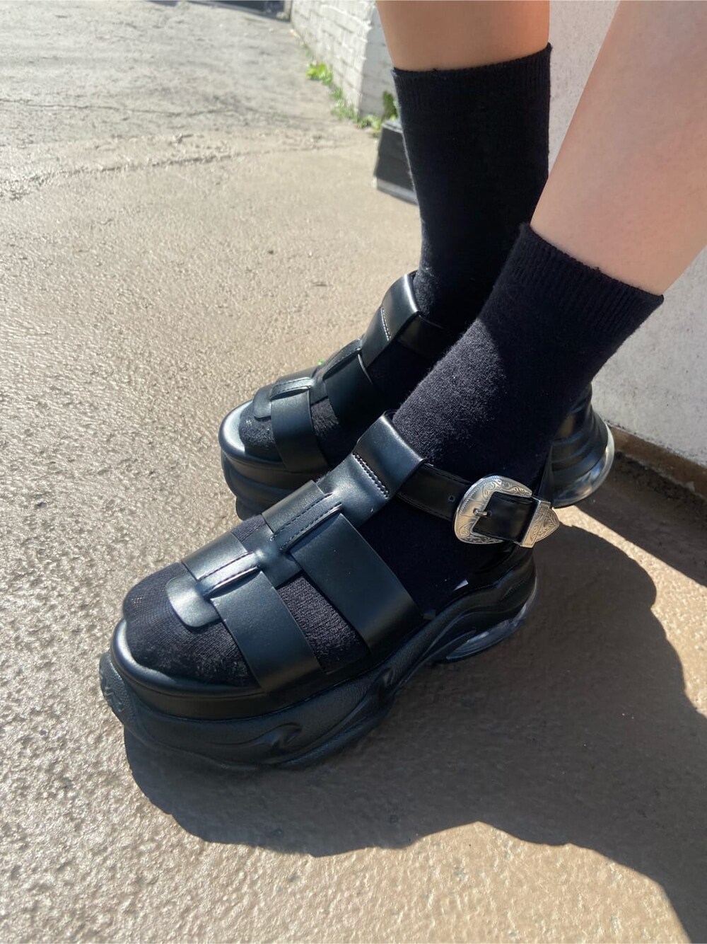 ベージュ系のテーラードジャケット、ブラック系のワンピース、ブラック系のサンダルを着用したレディースの春コーディネートの7枚目の写真