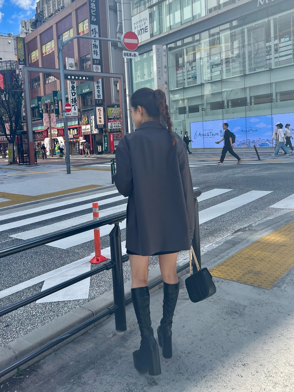 ブラック系のブーツ、ブラック系のショルダーバッグ、ブラック系のスカートを着用したレディースの秋コーディネートの4枚目の写真