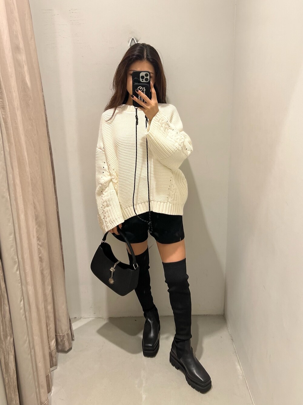 ホワイト系のニット/セーター、ブラック系のその他パンツ、ブラック系のブーツを着用したレディースの秋コーディネートの2枚目の写真