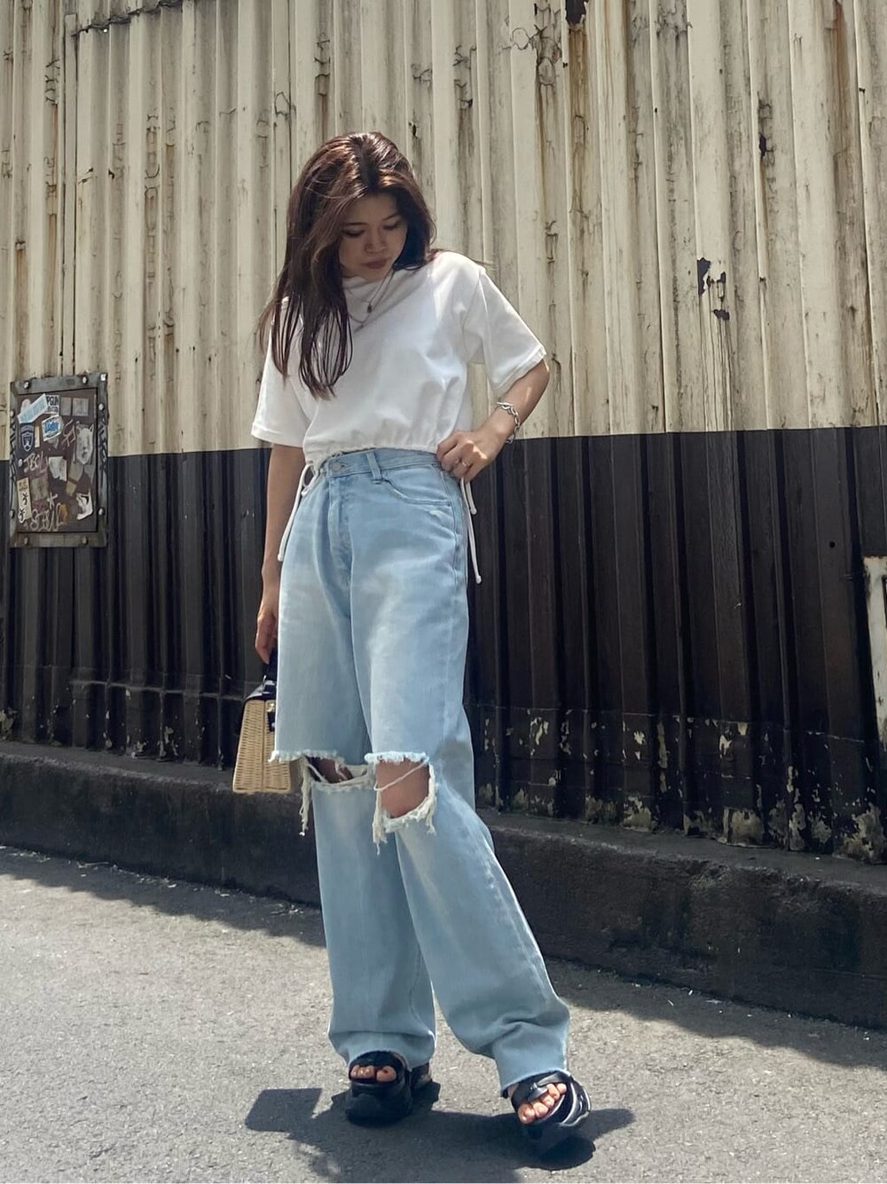 ブラック系のサンダル、ホワイト系のTシャツ/カットソー、ブルー系のデニムパンツを着用したレディースの夏コーディネートの5枚目の写真