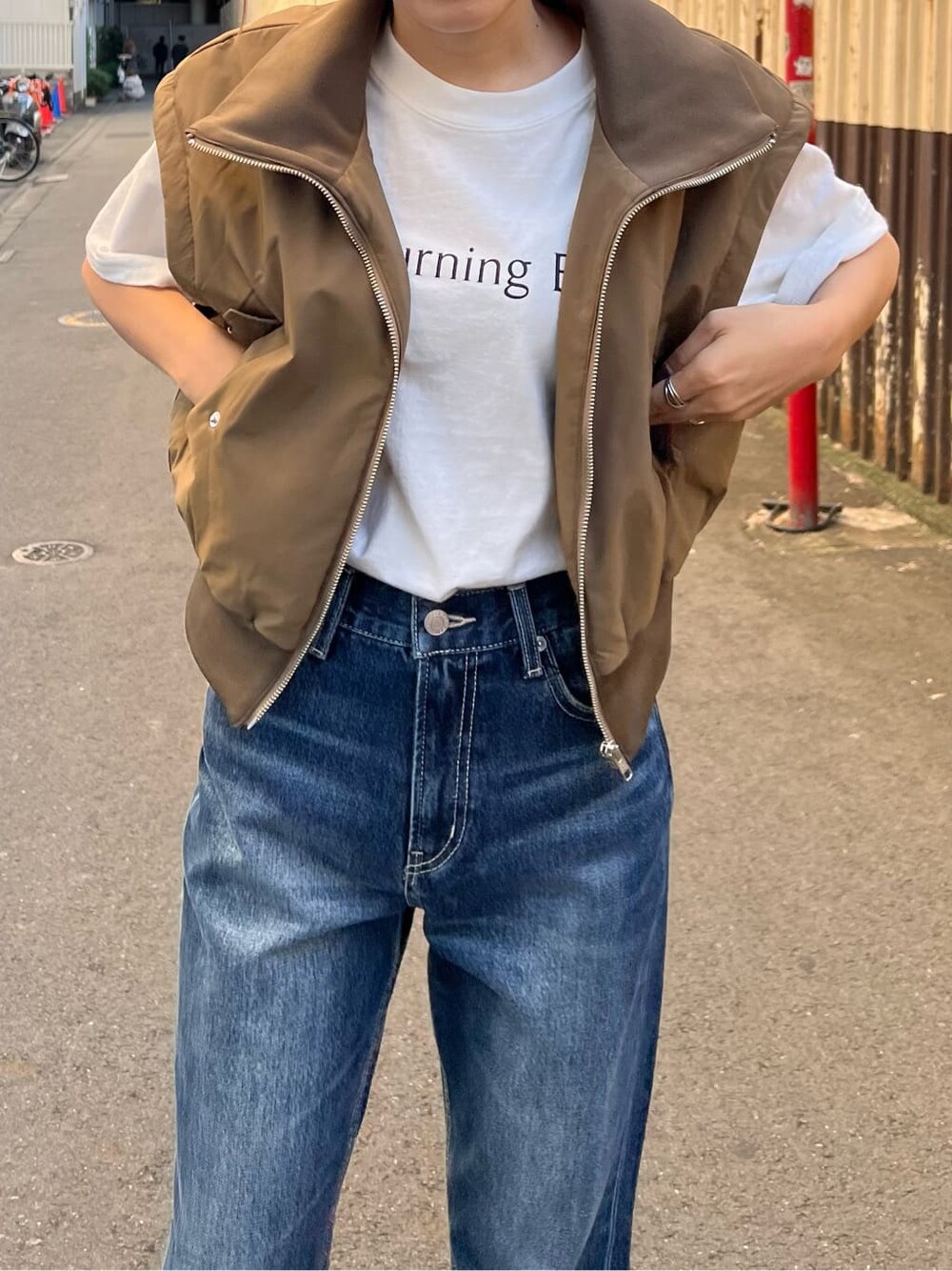 ブラック系のブーツ、ホワイト系のTシャツ/カットソー、ベージュ系のMA-1を着用したレディースの秋コーディネートの8枚目の写真