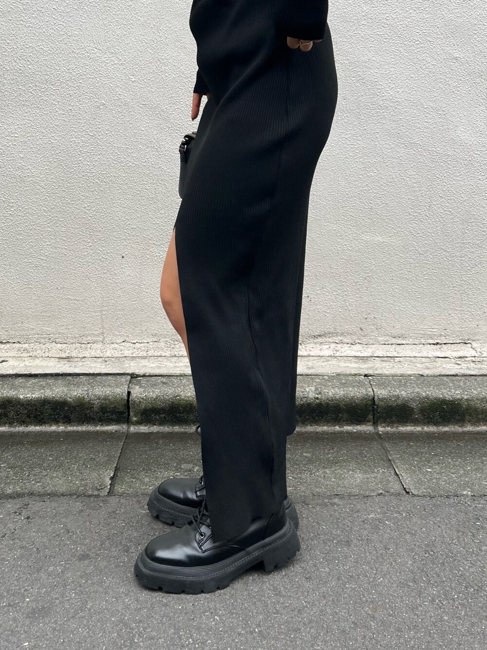 ブラック系のワンピース、ブラック系のショルダーバッグ、ブラック系のブーツを着用したレディースの秋コーディネートの5枚目の写真