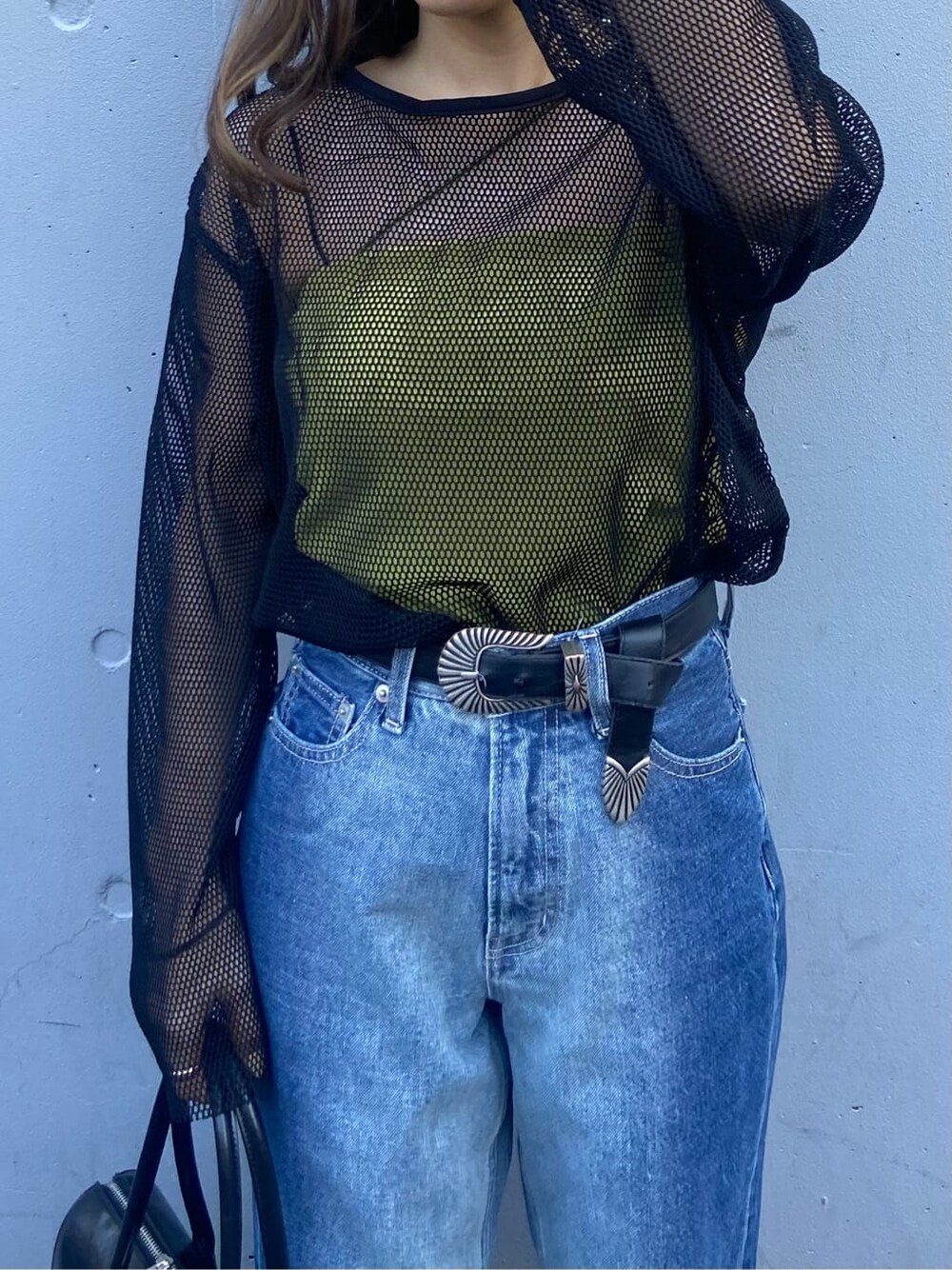 ブラック系のボストンバッグ、グリーン系のキャミソール、ブラック系のTシャツ/カットソーを着用したレディースの春コーディネートの6枚目の写真