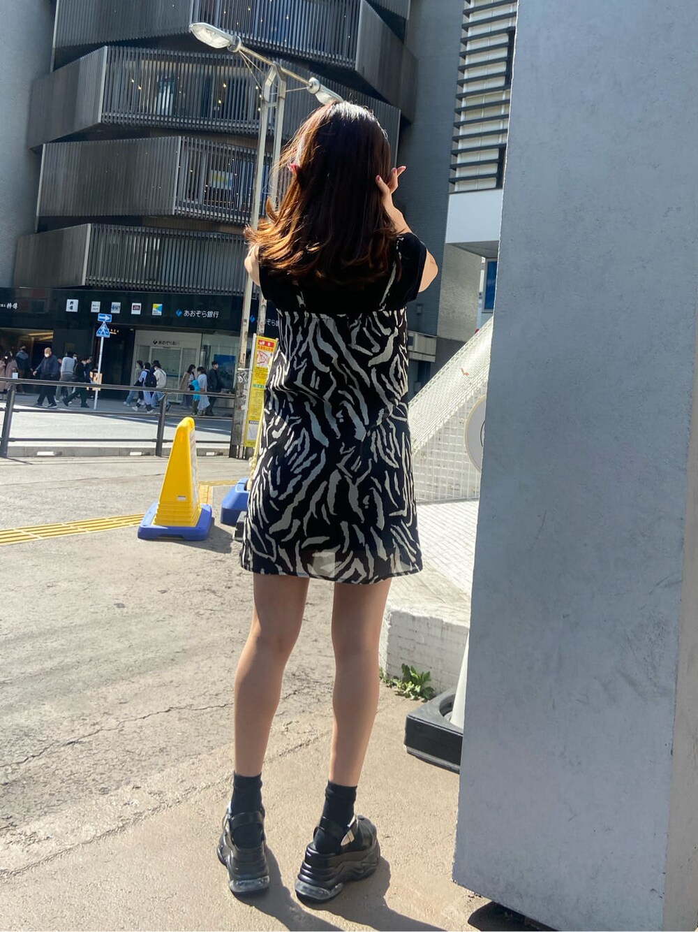 ベージュ系のテーラードジャケット、ブラック系のワンピース、ブラック系のサンダルを着用したレディースの春コーディネートの5枚目の写真