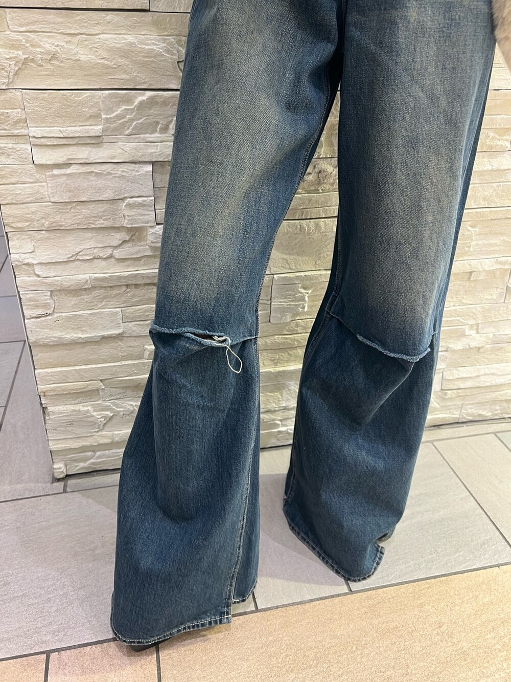 ブルー系のデニムパンツ、ホワイト系のショルダーバッグ、ブラック系のニット/セーターを着用したレディースの冬コーディネートの7枚目の写真