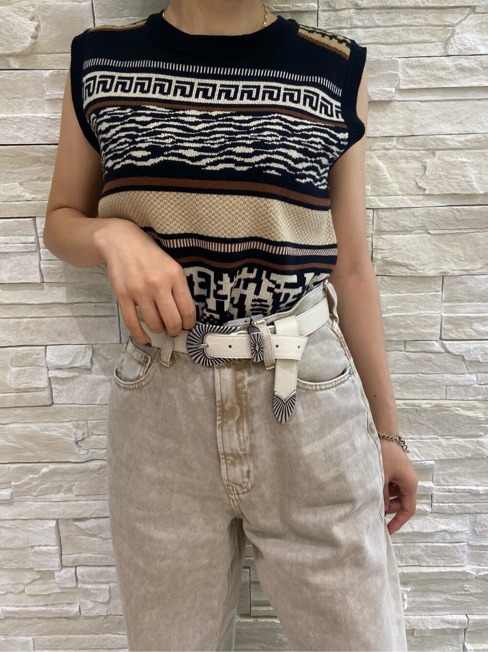 ブラック系のサンダル、ブラック系のタンクトップ、ベージュ系のデニムパンツを着用したレディースの夏コーディネートの4枚目の写真