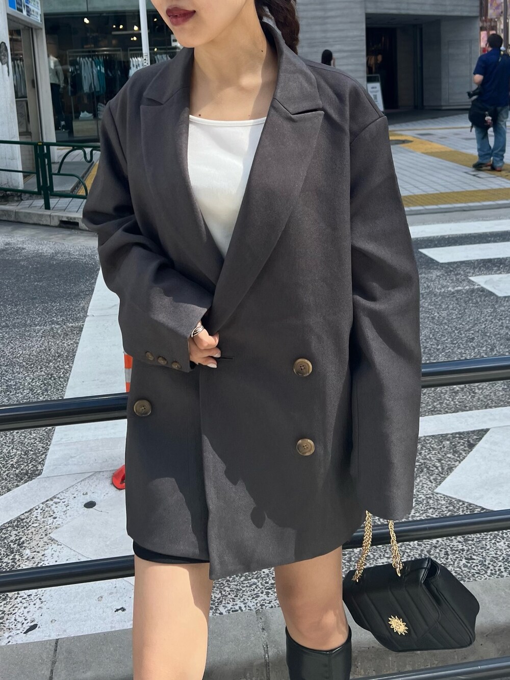 ブラック系のブーツ、ブラック系のショルダーバッグ、ブラック系のスカートを着用したレディースの秋コーディネートの8枚目の写真