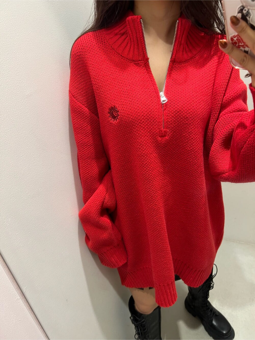 ブラック系のブーツ、レッド系のニット/セーター、ブラック系のスカートを着用したレディースの秋コーディネートの3枚目の写真