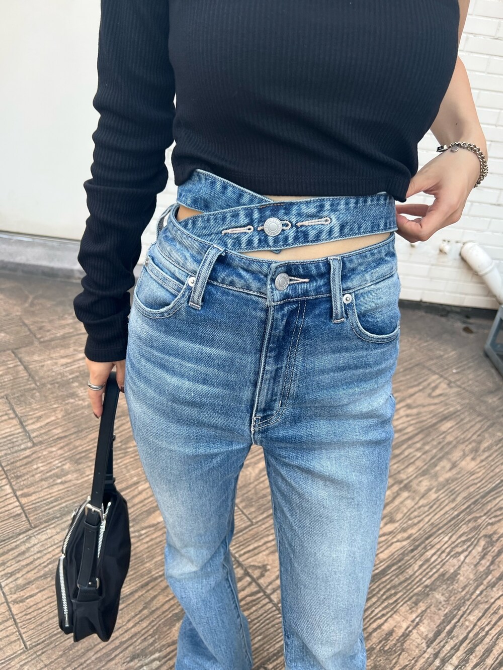 ブラック系のTシャツ/カットソー、ブラック系のサンダル、ブルー系のデニムパンツを着用したレディースの夏コーディネートの7枚目の写真