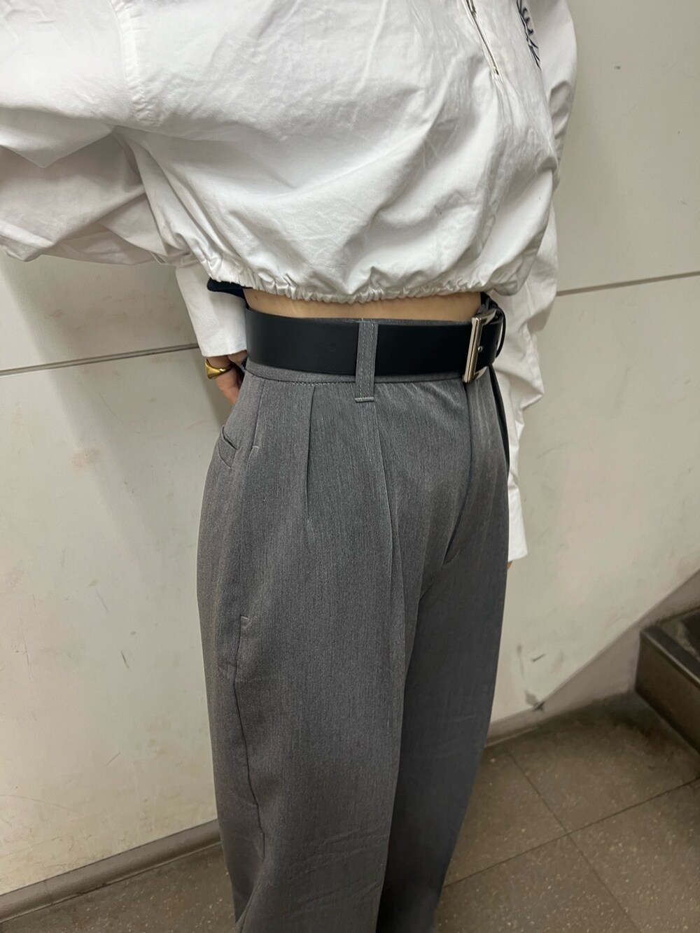 グレー系のその他パンツ、ブラック系のブーツ、ホワイト系のシャツ/ブラウスを着用したレディースの春コーディネートの7枚目の写真