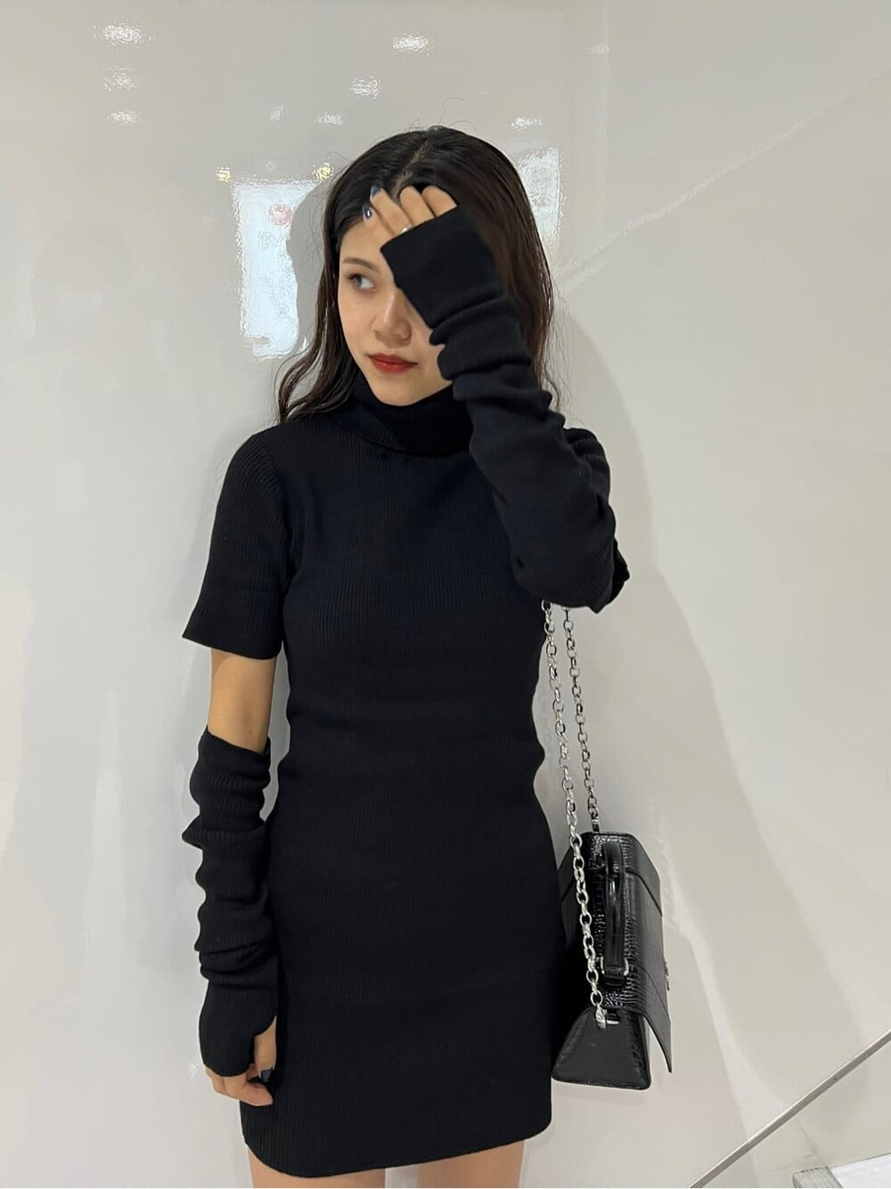 ブラック系のワンピース、ブラック系のブーツ、ブラック系のショルダーバッグを着用したレディースの秋コーディネートの6枚目の写真