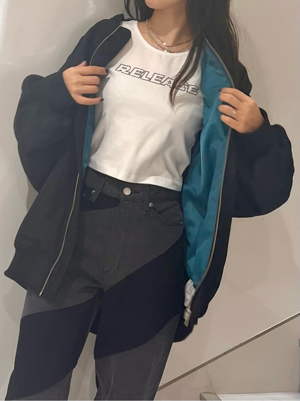 ブラック系のMA-1、ホワイト系のTシャツ/カットソー、ブラック系のデニムパンツを着用したレディースの秋コーディネートの6枚目の写真