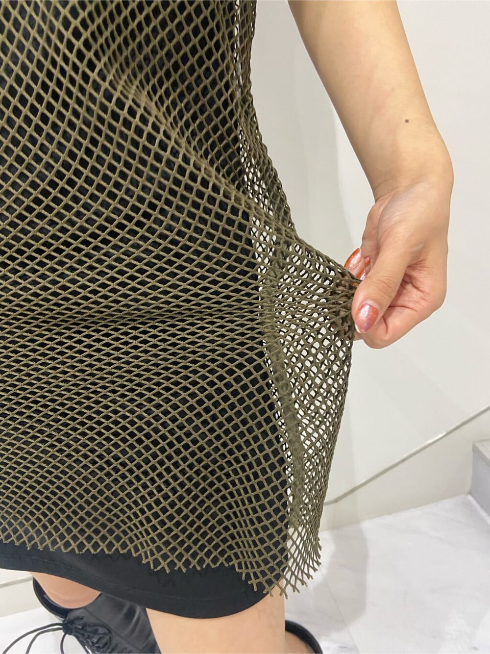 ブラック系のブーツ、ホワイト系のショルダーバッグ、ブラック系のワンピースを着用したレディースの夏コーディネートの8枚目の写真