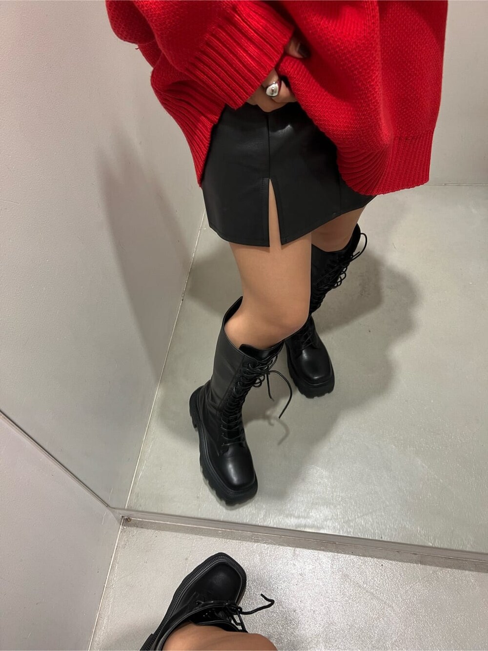 ブラック系のブーツ、レッド系のニット/セーター、ブラック系のスカートを着用したレディースの秋コーディネートの5枚目の写真