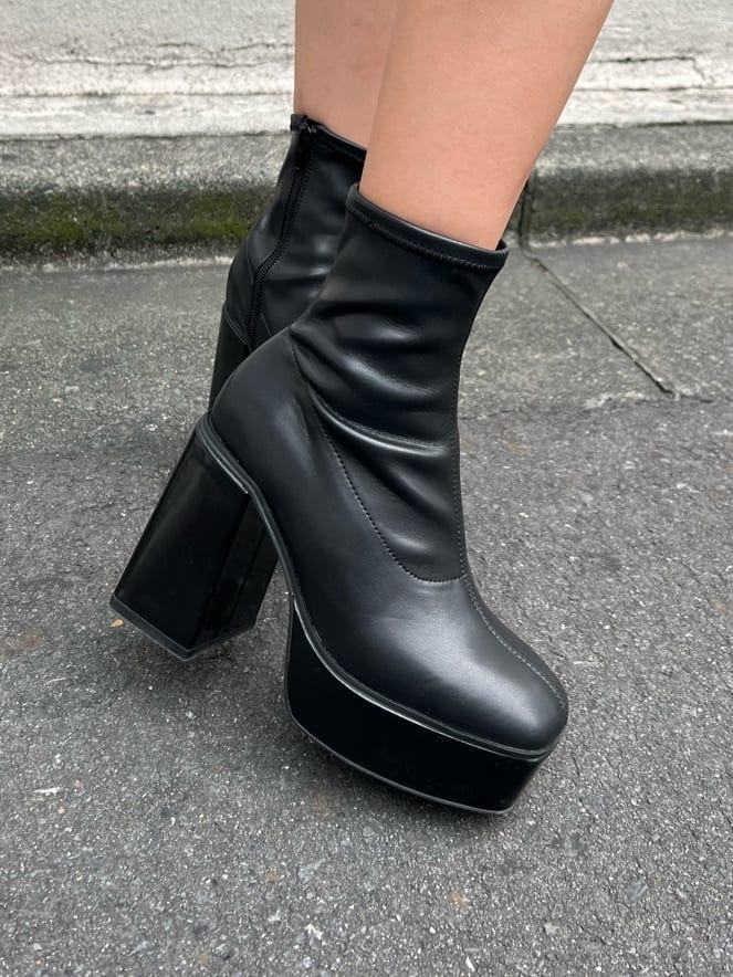 ブラック系のブーツ、ブラック系のデニムパンツ、ブルー系のニット/セーターを着用したレディースの秋コーディネートの8枚目の写真