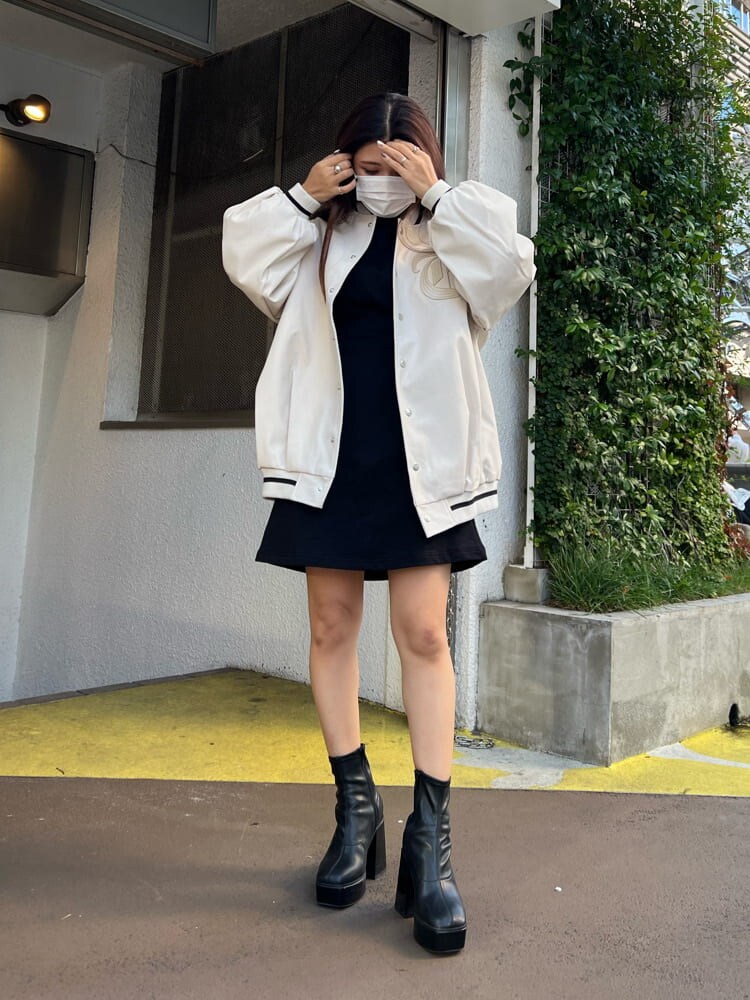 ブラック系のブーツ、ブラック系のワンピース、ホワイト系のスタジャンを着用したレディースの秋コーディネートの6枚目の写真