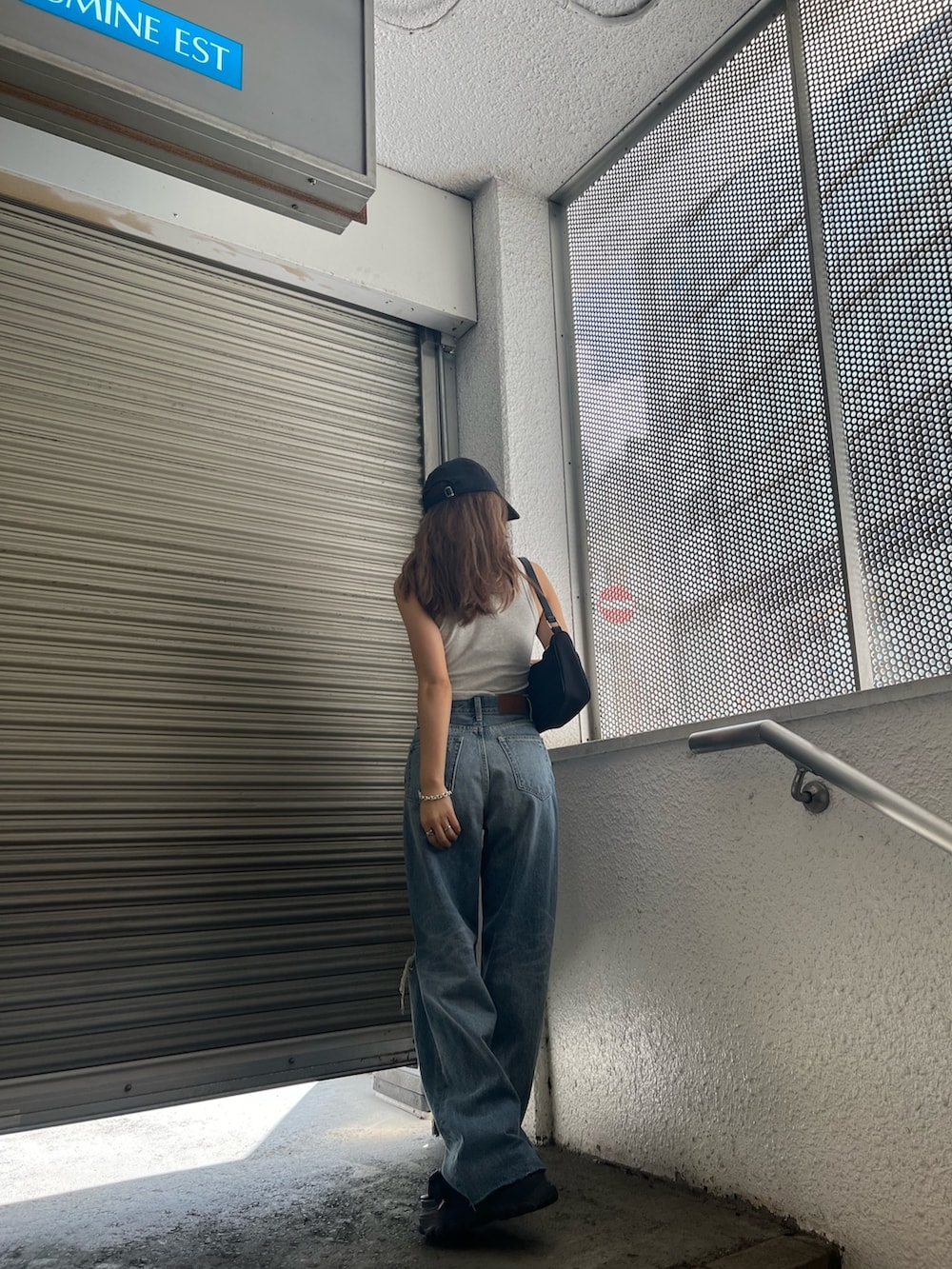 ブラック系のサンダル、ブルー系のデニムパンツ、グレー系のタンクトップを着用したレディースの夏コーディネートの5枚目の写真