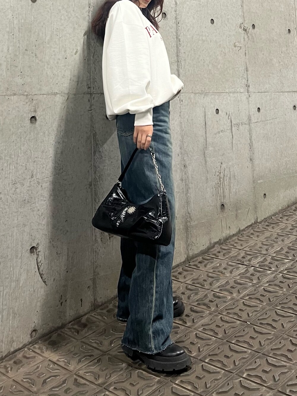 ブルー系のデニムパンツ、ブラック系のブーツ、ブラック系のハンドバッグを着用したレディースの冬コーディネートの3枚目の写真