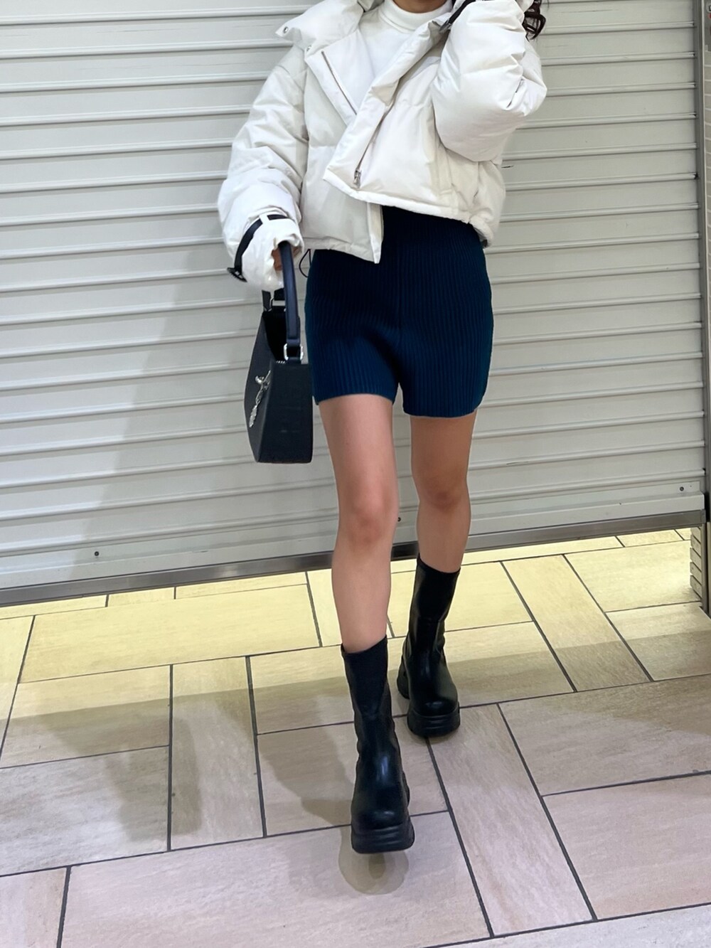 ブルー系のその他パンツ、ホワイト系のTシャツ/カットソー、ホワイト系のダウンジャケット/コートを着用したレディースの秋コーディネートの5枚目の写真