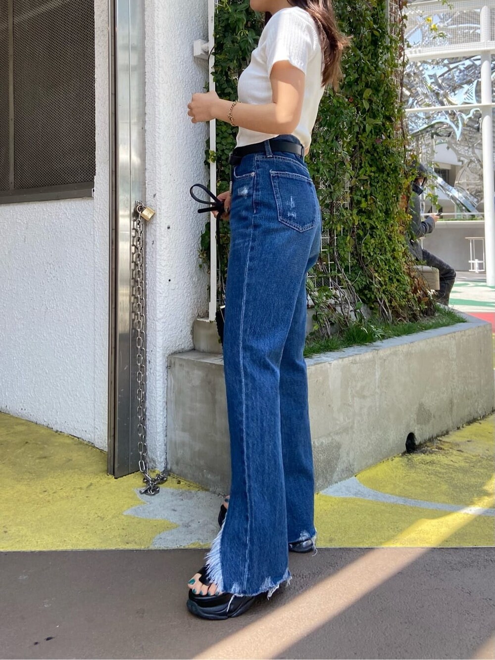 ブラック系のショルダーバッグ、ホワイト系のTシャツ/カットソー、ブルー系のデニムパンツを着用したレディースの春コーディネートの3枚目の写真