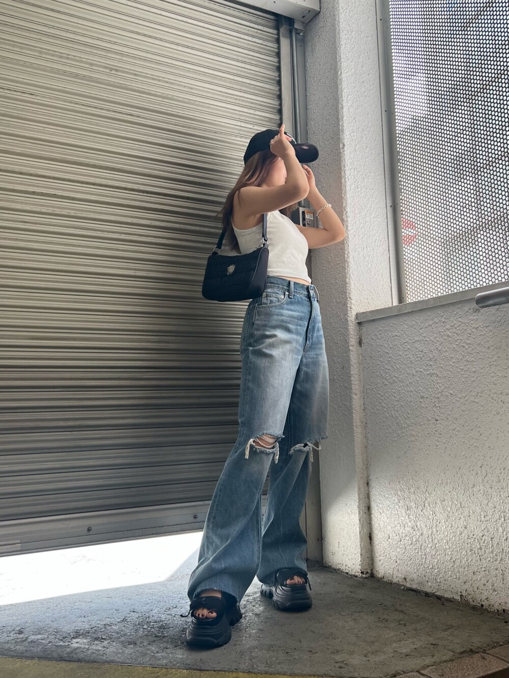 ブラック系のサンダル、ブルー系のデニムパンツ、グレー系のタンクトップを着用したレディースの夏コーディネートの3枚目の写真