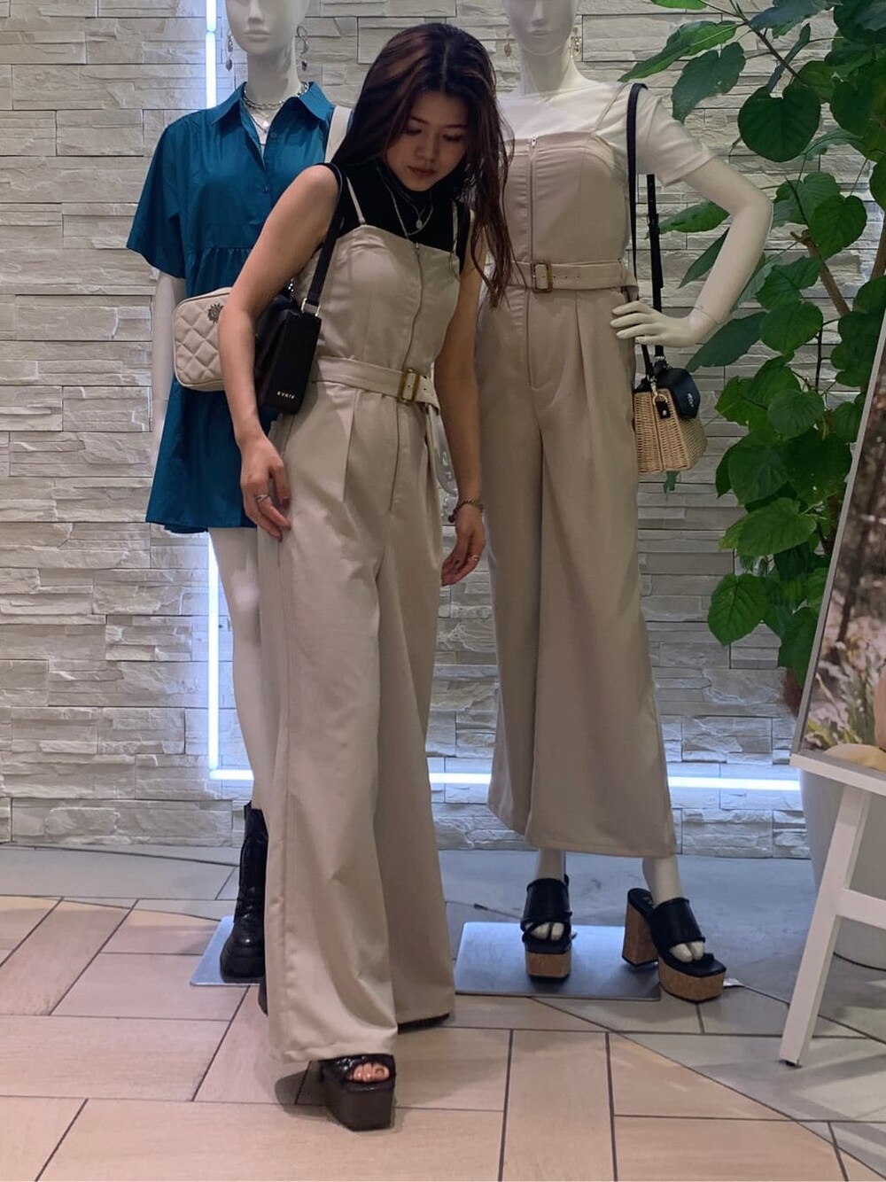 ブラック系のタンクトップ、ホワイト系のサロペット/オーバーオール、ブラック系のショルダーバッグを着用したレディースの夏コーディネートの2枚目の写真