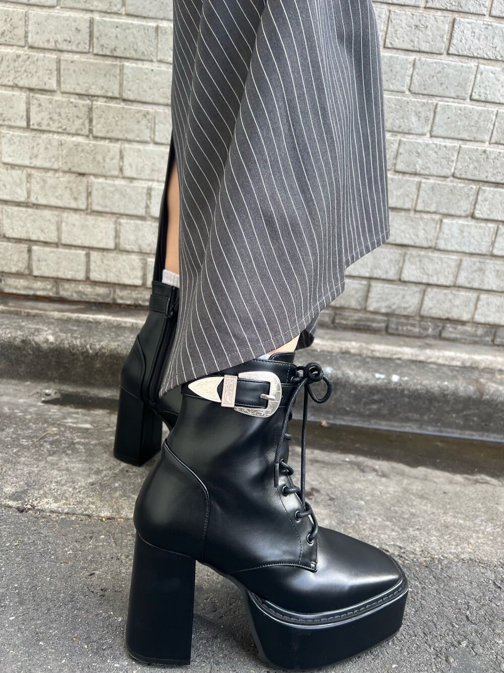 グレー系のスカート、ブラック系のニット/セーター、ブルー系のショルダーバッグを着用したレディースの冬コーディネートの7枚目の写真