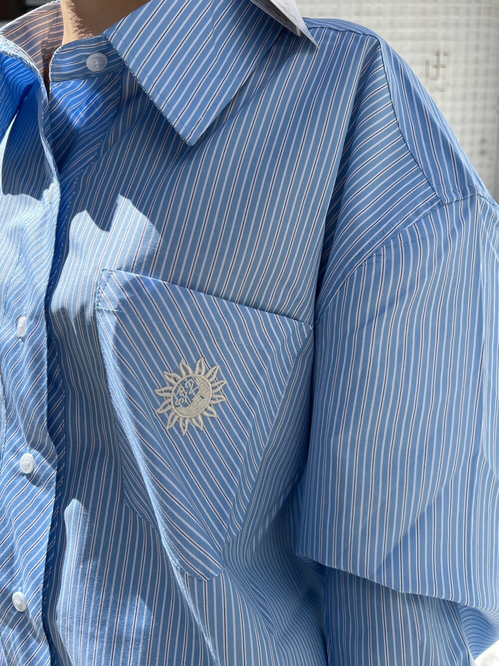 ブラック系のブーツ、ブラック系のテーラードジャケット、ブルー系のシャツ/ブラウスを着用したレディースの春コーディネートの6枚目の写真