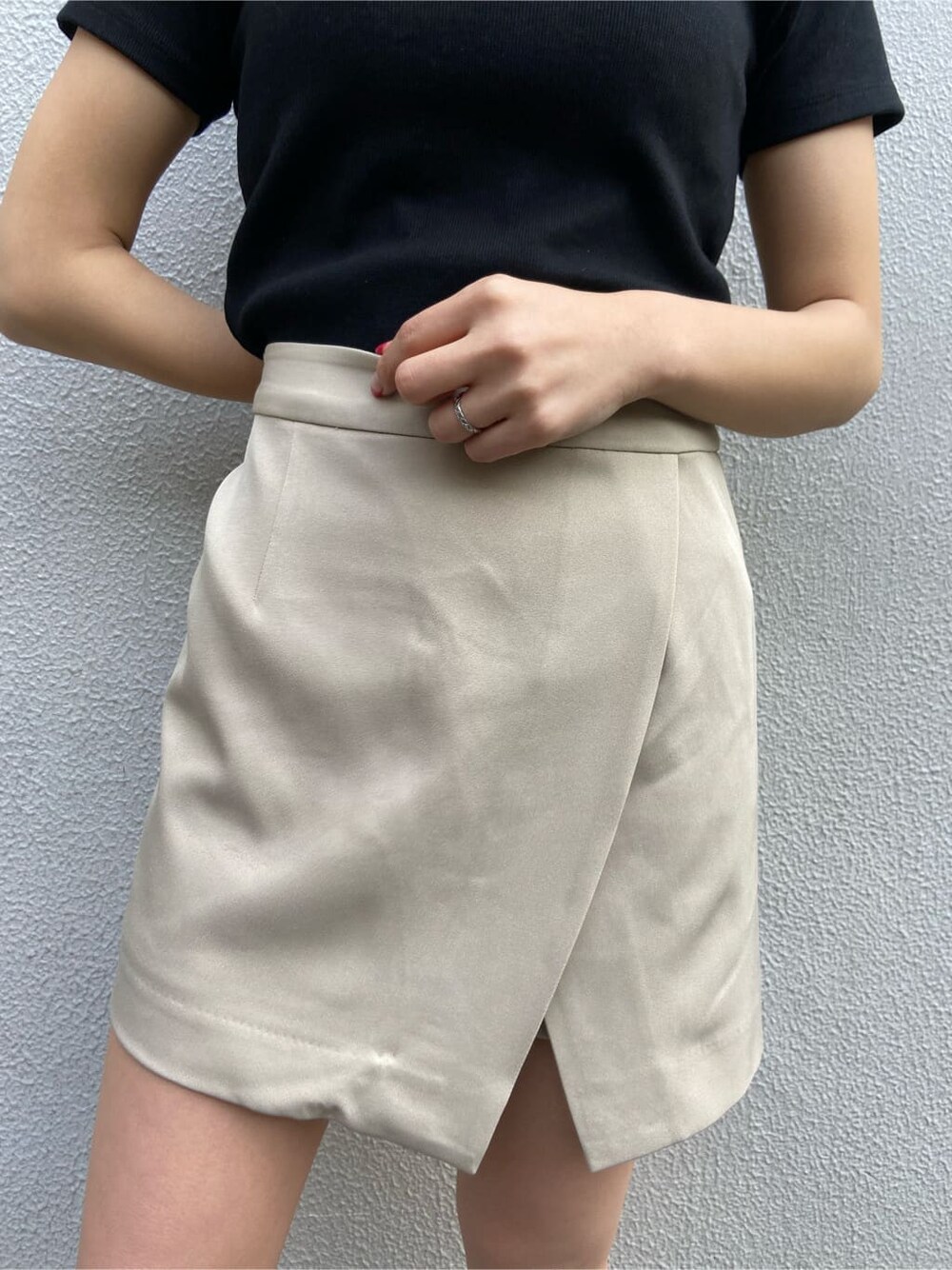 ブラック系のショルダーバッグ、ブラック系のTシャツ/カットソー、ベージュ系のスカートを着用したレディースの春コーディネートの4枚目の写真