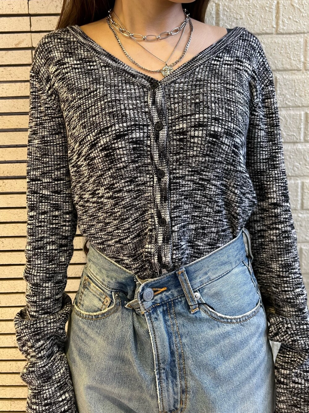 ブルー系のデニムパンツ、ブラック系のハンドバッグ、ブラック系のニット/セーターを着用したレディースの冬コーディネートの5枚目の写真