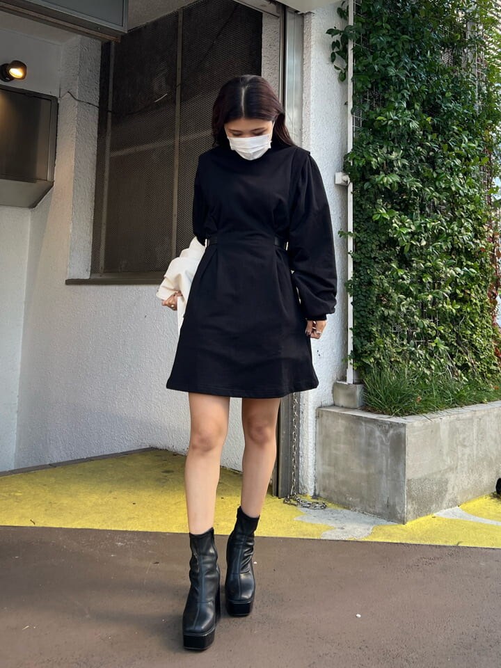 ブラック系のブーツ、ブラック系のワンピース、ホワイト系のスタジャンを着用したレディースの秋コーディネートの3枚目の写真