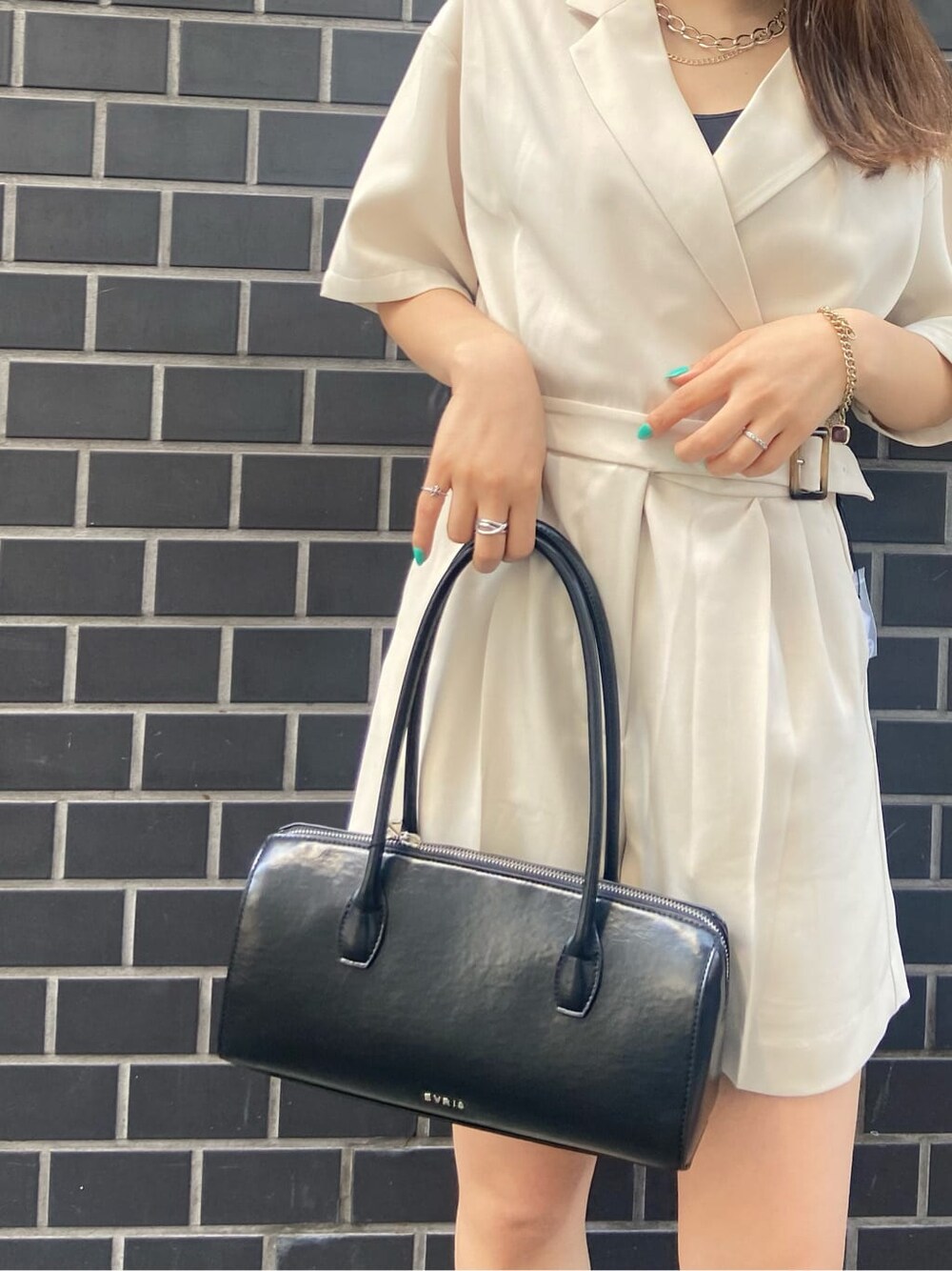 ブラック系のボストンバッグ、ブラック系のキャミソール、ホワイト系のつなぎ/オールインワンを着用したレディースの春コーディネートの2枚目の写真