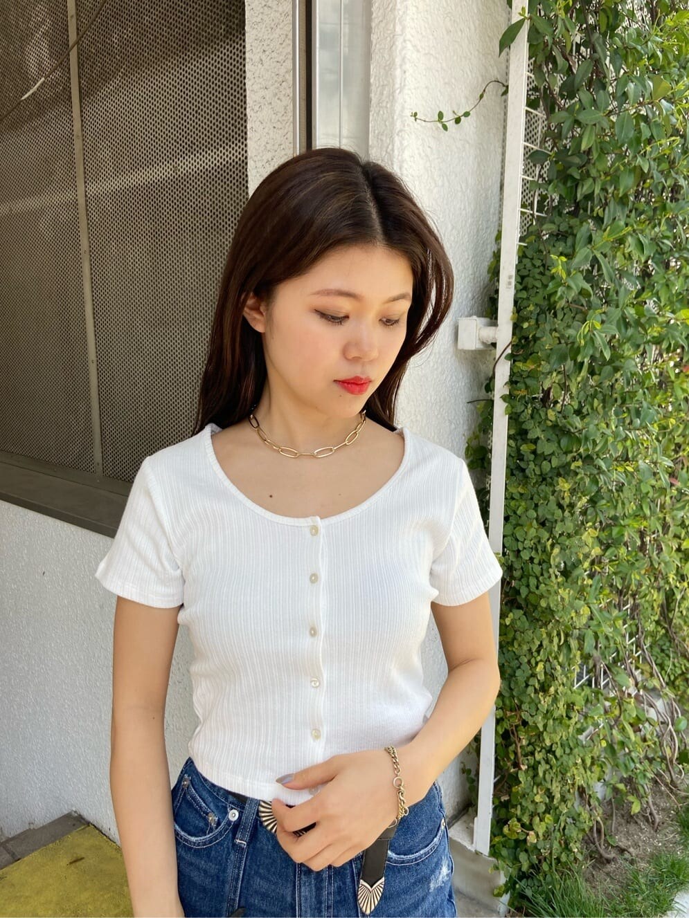 ブラック系のショルダーバッグ、ホワイト系のTシャツ/カットソー、ブルー系のデニムパンツを着用したレディースの春コーディネートの4枚目の写真