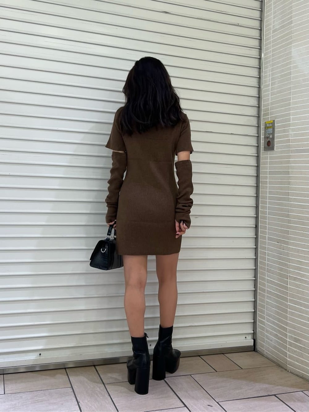 ブラウン系のワンピース、ブラック系のブーツ、ブラック系のショルダーバッグを着用したレディースの秋コーディネートの4枚目の写真
