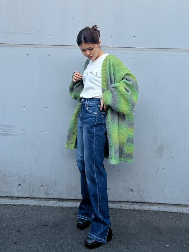 ブラック系のブーツ、ホワイト系のTシャツ/カットソー、ブルー系のデニムパンツを着用したレディースの秋コーディネートの5枚目の写真