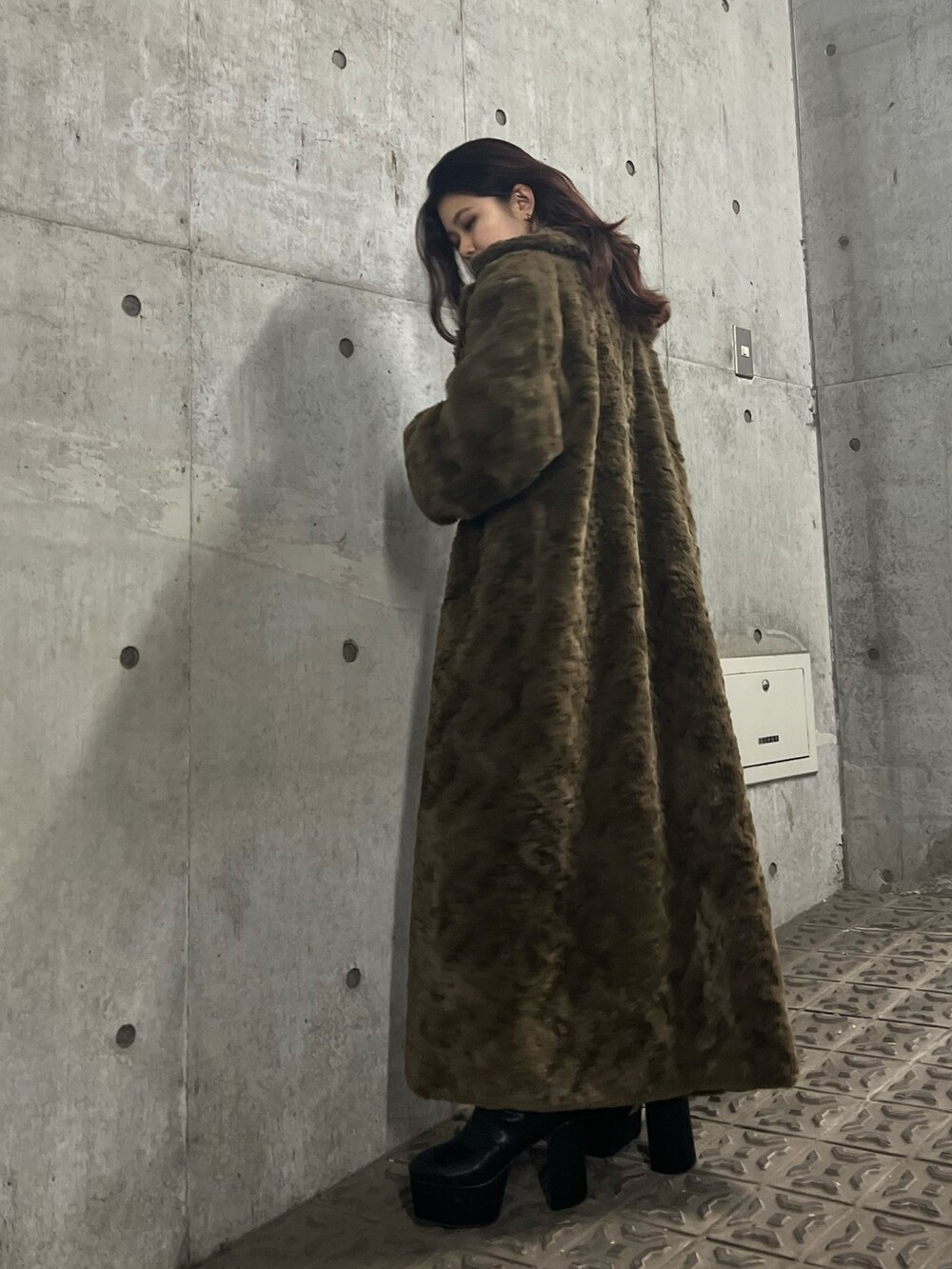 ブラック系のブーツ、ブラウン系のチェスターコート、ブラック系のワンピースを着用したレディースの冬コーディネートの7枚目の写真