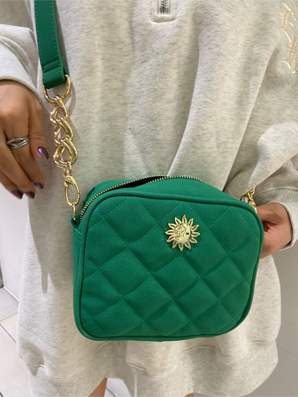 ブラック系のブーツ、グリーン系のショルダーバッグ、ホワイト系のスウェットを着用したレディースの夏コーディネートの9枚目の写真